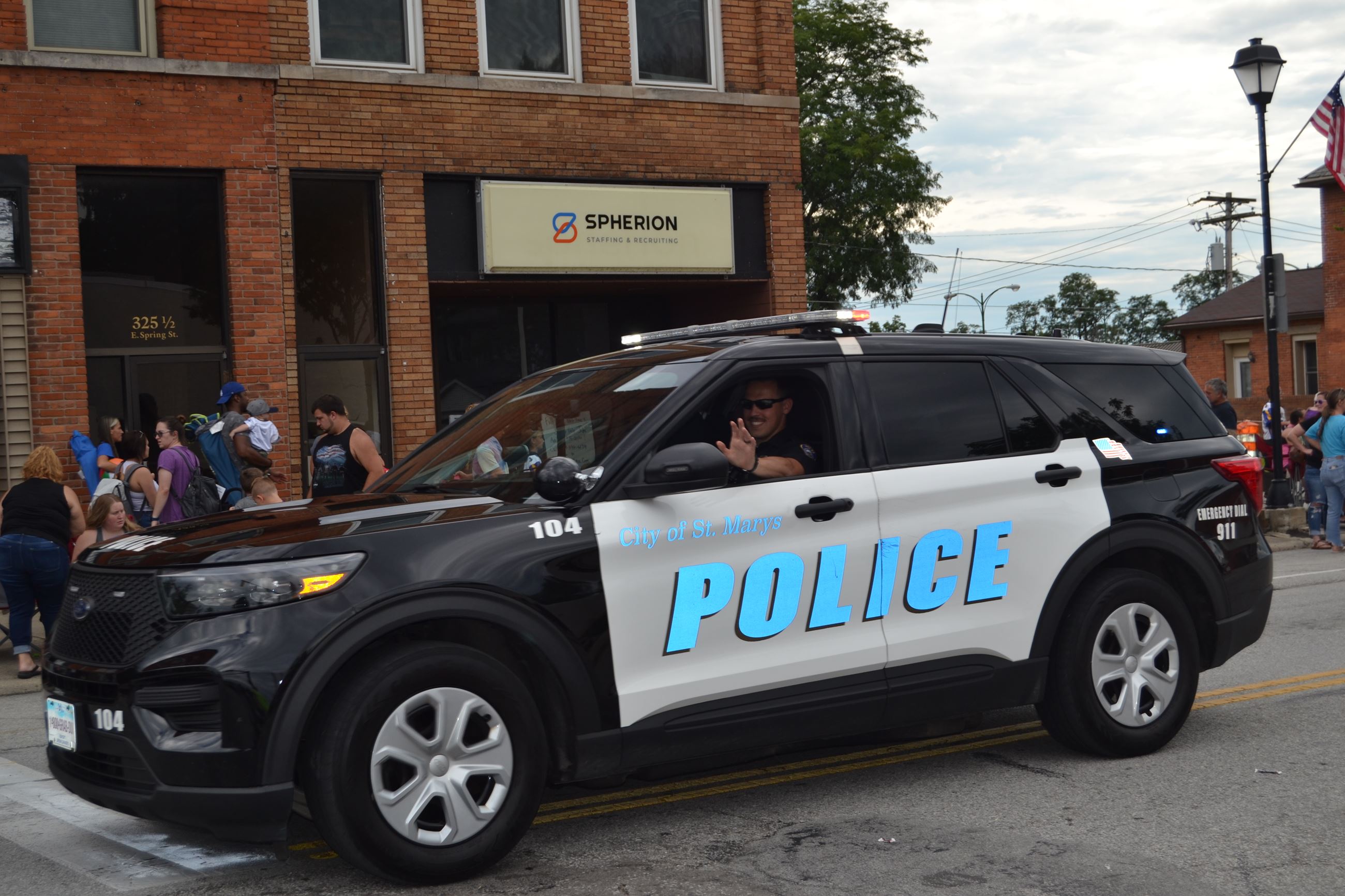 Police Officer waiving from car in parade