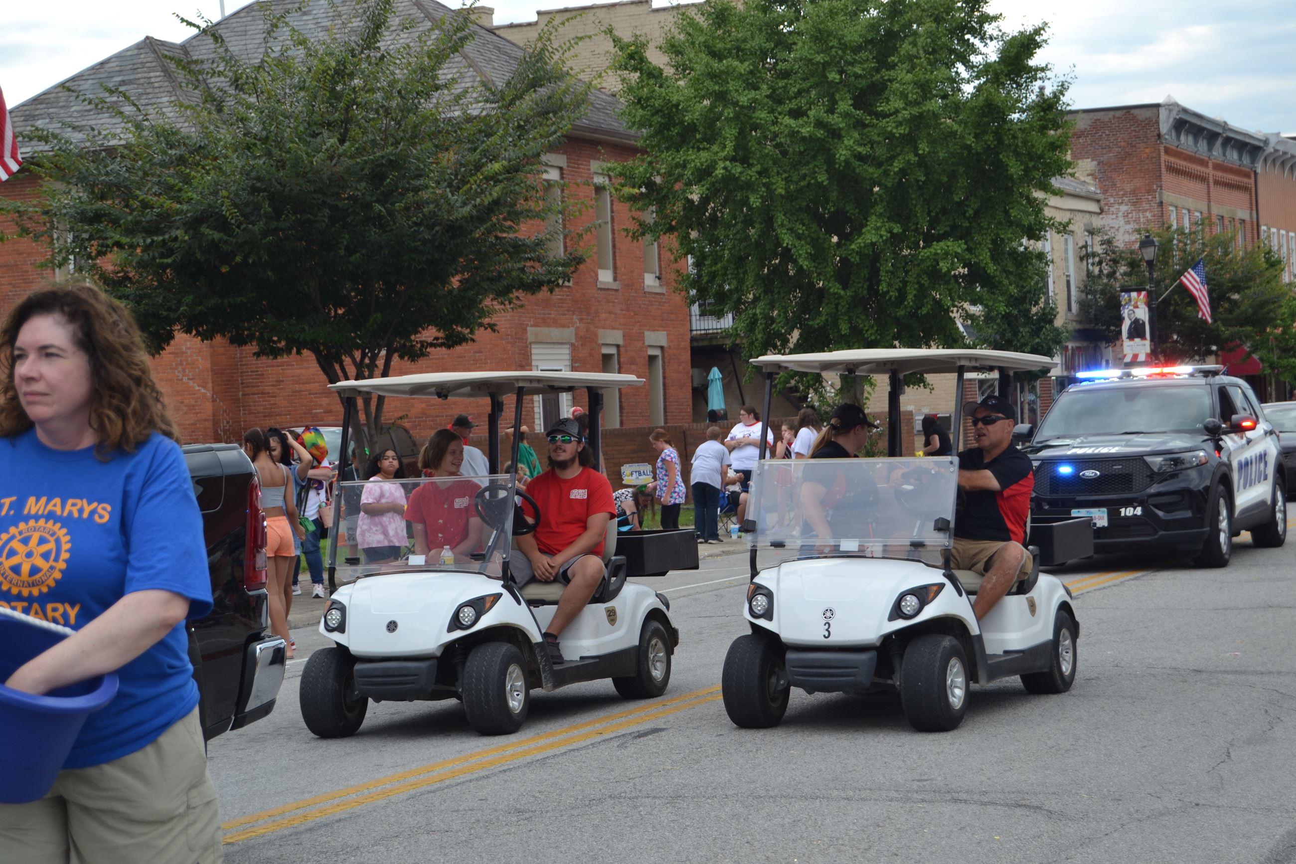 People riding in golf carts in parade