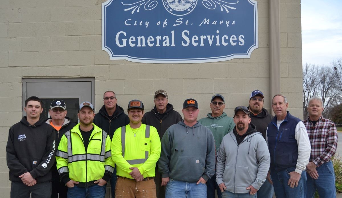 Photo of workers in standing in front on building 