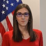 Lady standing in front of flag