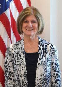 Lady standing in front of flag