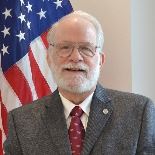 Man standing in front of flag