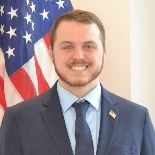 Man standing in front of flag