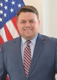 Man standing in front of flag