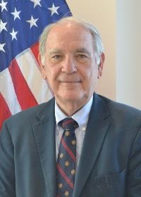 Man standing in front of flag
