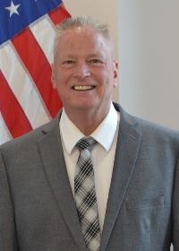 Man standing in front of flag