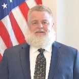 Man standing in front of flag