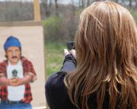 Person Aiming Gun at Target